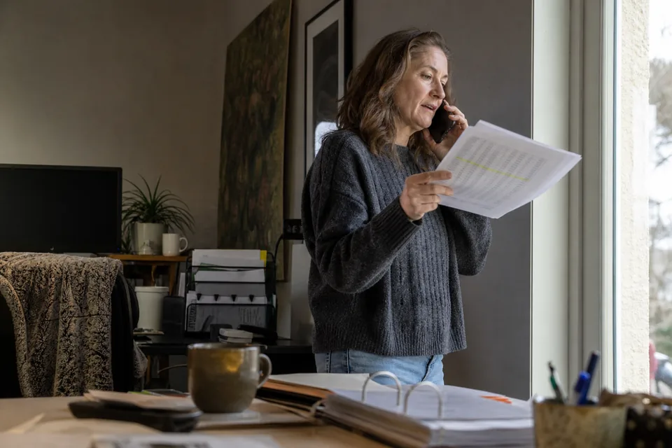 Domain broker on a phone call holding a printed valuation report